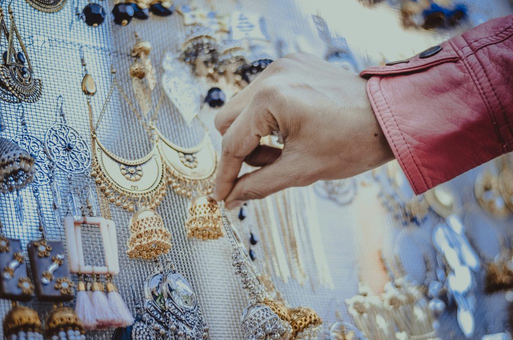 persona tocando aretes de oro
